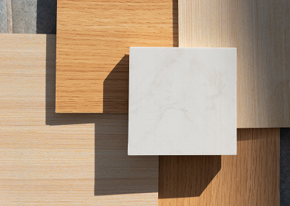 A collection of different wood and marble samples displayed on a wooden surface, showcasing their textures and colors.